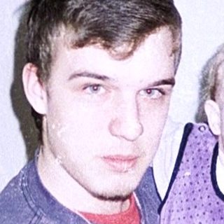 A man holds a young child indoors.