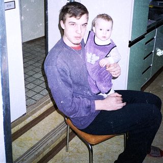 A man holds a young child indoors.