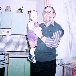 A man holding a baby in a kitchen.
