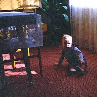 Two young children playing on a red carpet.