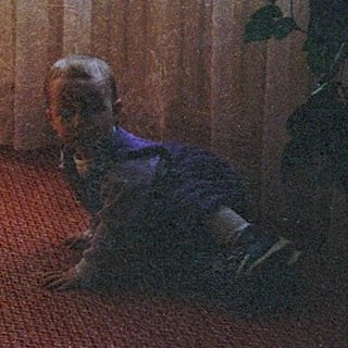Two young children playing on a red carpet.
