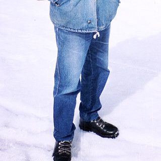 Man in winter gear posing in snowy forest.