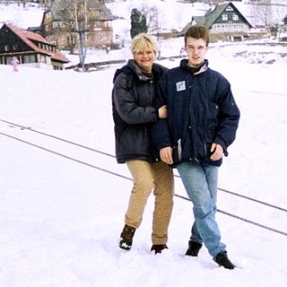 Two people standing on snow-covered ski slope.