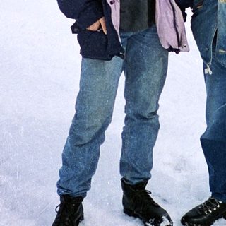 Two men posing in snowy village landscape.