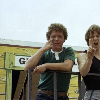 Two men reacting excitedly near a Horn Hotel.