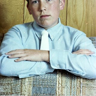 Young boy in light blue shirt and tie.