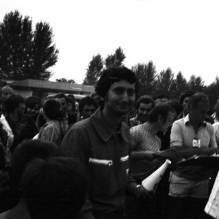 Group of people gathered outdoors, shaking hands.