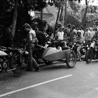 Classic motorcycles with sidecars, vintage road rally participants.