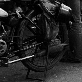 Classic motorcycles with sidecars, vintage road rally participants.