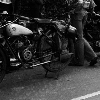 Classic motorcycles with sidecars, vintage road rally participants.