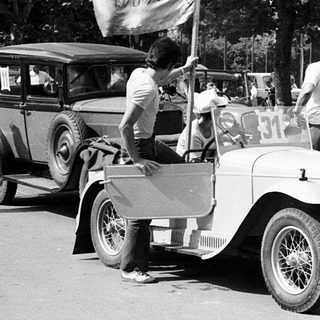 Vintage cars parade with vintage flags.