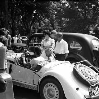 Classic cars with people gathered around.