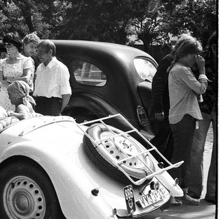 Classic cars with people gathered around.