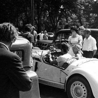 Classic cars with people gathered around.