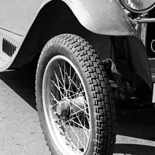 Vintage car rally with spectators and vintage vehicles.