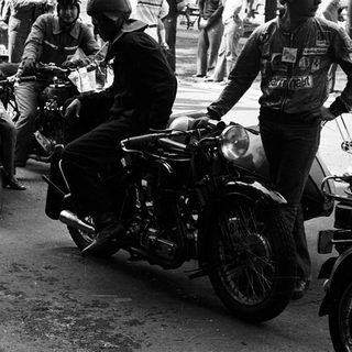 Motorcyclists participating in vintage race event.