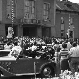 Large crowd gathering outside historic building during public event.