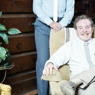 Two people posing indoors in casual attire.