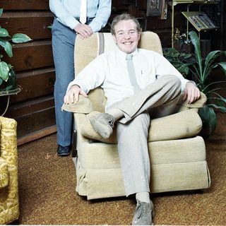 Two people posing indoors in casual attire.