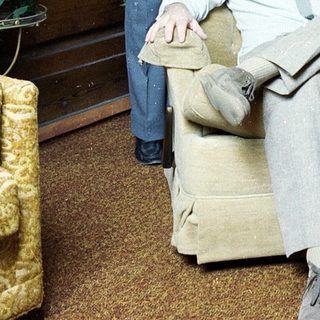 Two men posing indoors, one seated, one standing.