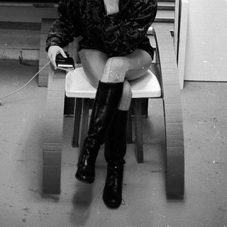 Person sitting on chair in office-like setting.