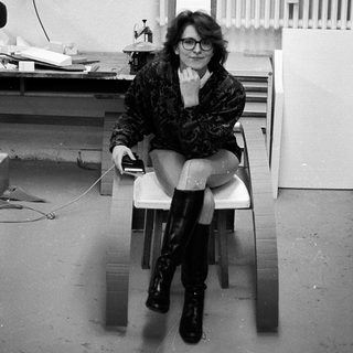 Person sitting on chair in office-like setting.