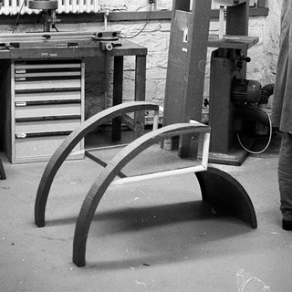 Woodshop with band saw and curved woodwork in progress.