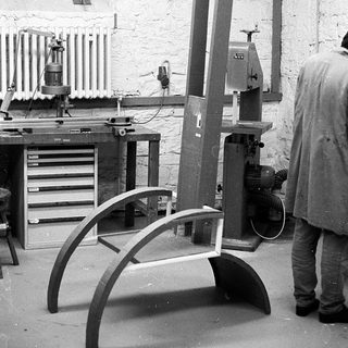 Woodshop with band saw and curved woodwork in progress.