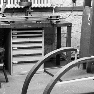 Woodshop with band saw and curved woodwork in progress.