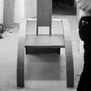 Industrial workshop with drill press and unfinished wooden bench.
