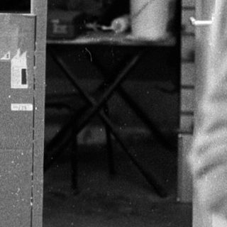 Industrial workshop with drill press and unfinished wooden bench.