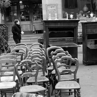 Empty outdoor café seating area with vintage furniture.