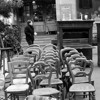 Empty outdoor café seating area with vintage furniture.