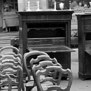 Empty outdoor café seating area with vintage furniture.