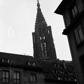 Gothic cathedral spire rising above urban buildings.
