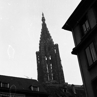 Gothic cathedral spire rising above urban buildings.