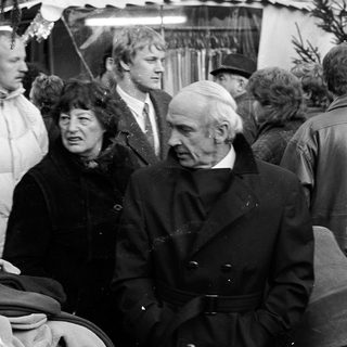 Group of people at an indoor market or fair.
