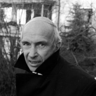 Black-and-white portrait of elderly man in winter attire.