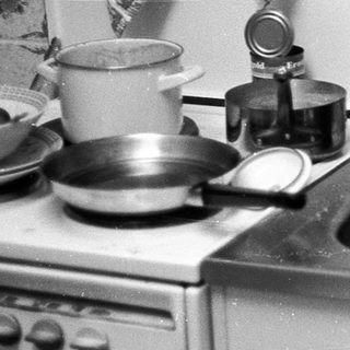 Vintage kitchen with stove, sink, and dishes.