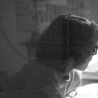 Silhouette of person working at blurred desk.