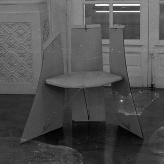 Abandoned room with broken furniture and shattered glass.