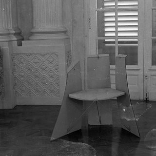 Abandoned room with broken furniture and shattered glass.