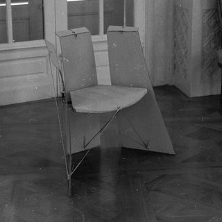Empty room with folding chair, ornate chair, open shuttered window.