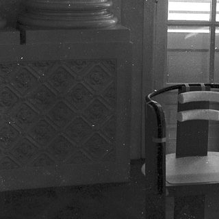 Empty room with modern chair, classical column, wet floor.