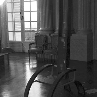 Elegant room with classical furniture, large windows.
