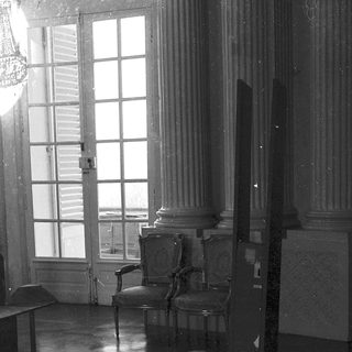 Elegant room with classical furniture, large windows.