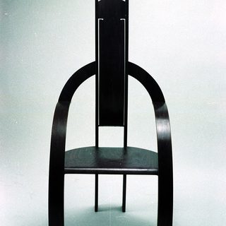 Modern black wooden chair with curved, minimalist design.