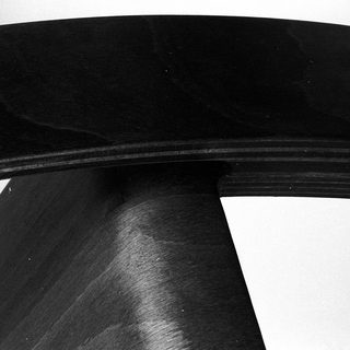 Curved dark wooden or metal table leg.