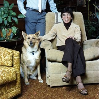 Family portrait with man, boy, and dog indoors.