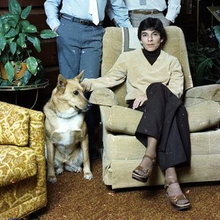 Family portrait with two boys, woman, and dog indoors.